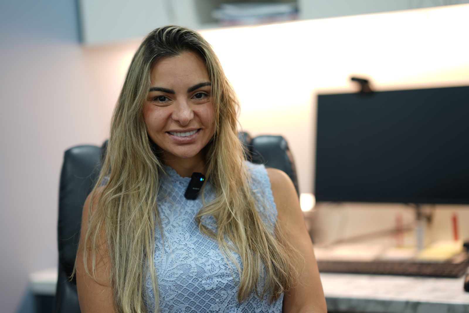 A clinician smiling in her consulting room