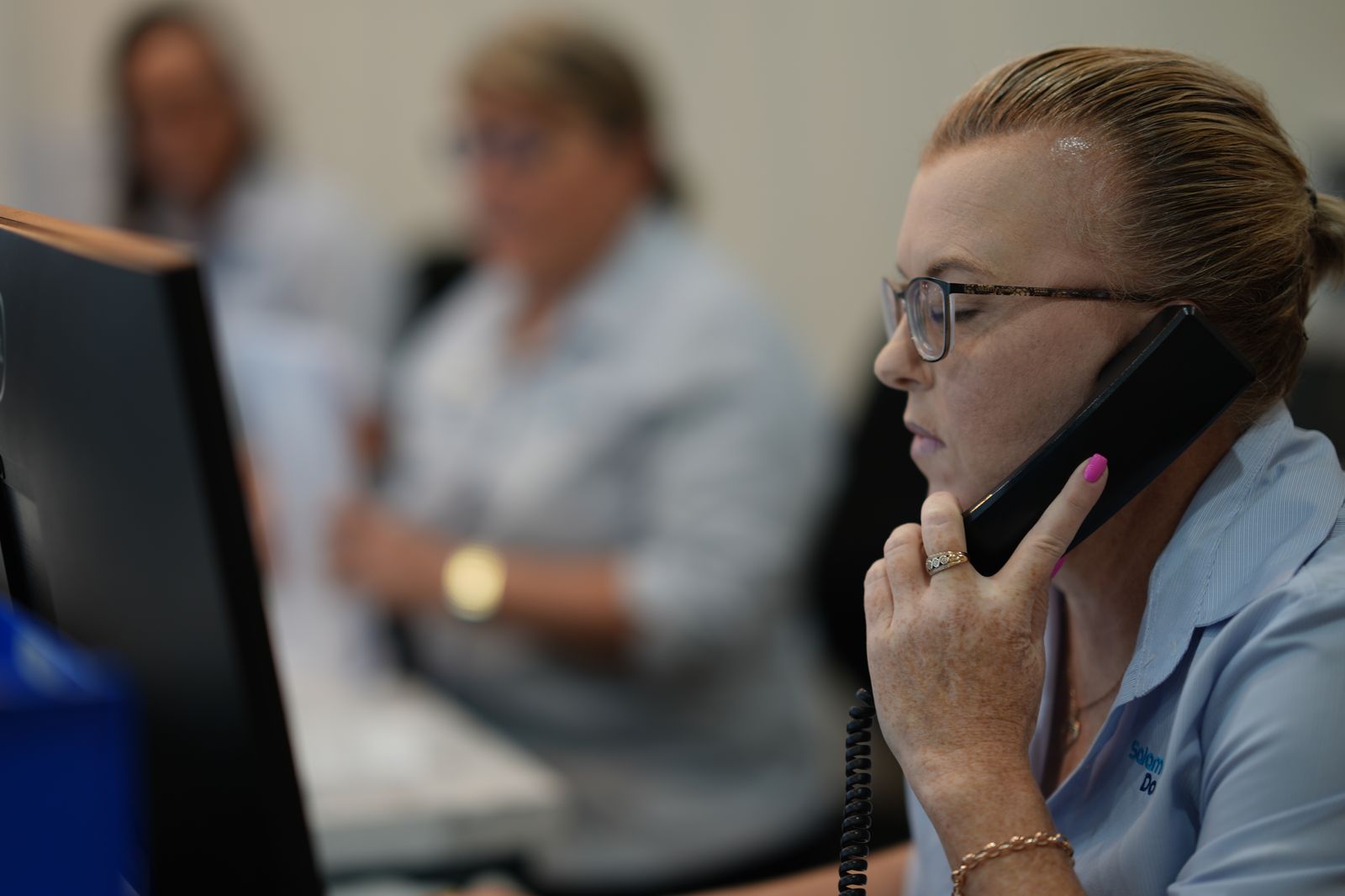 A receptionist taking a booking over the phone