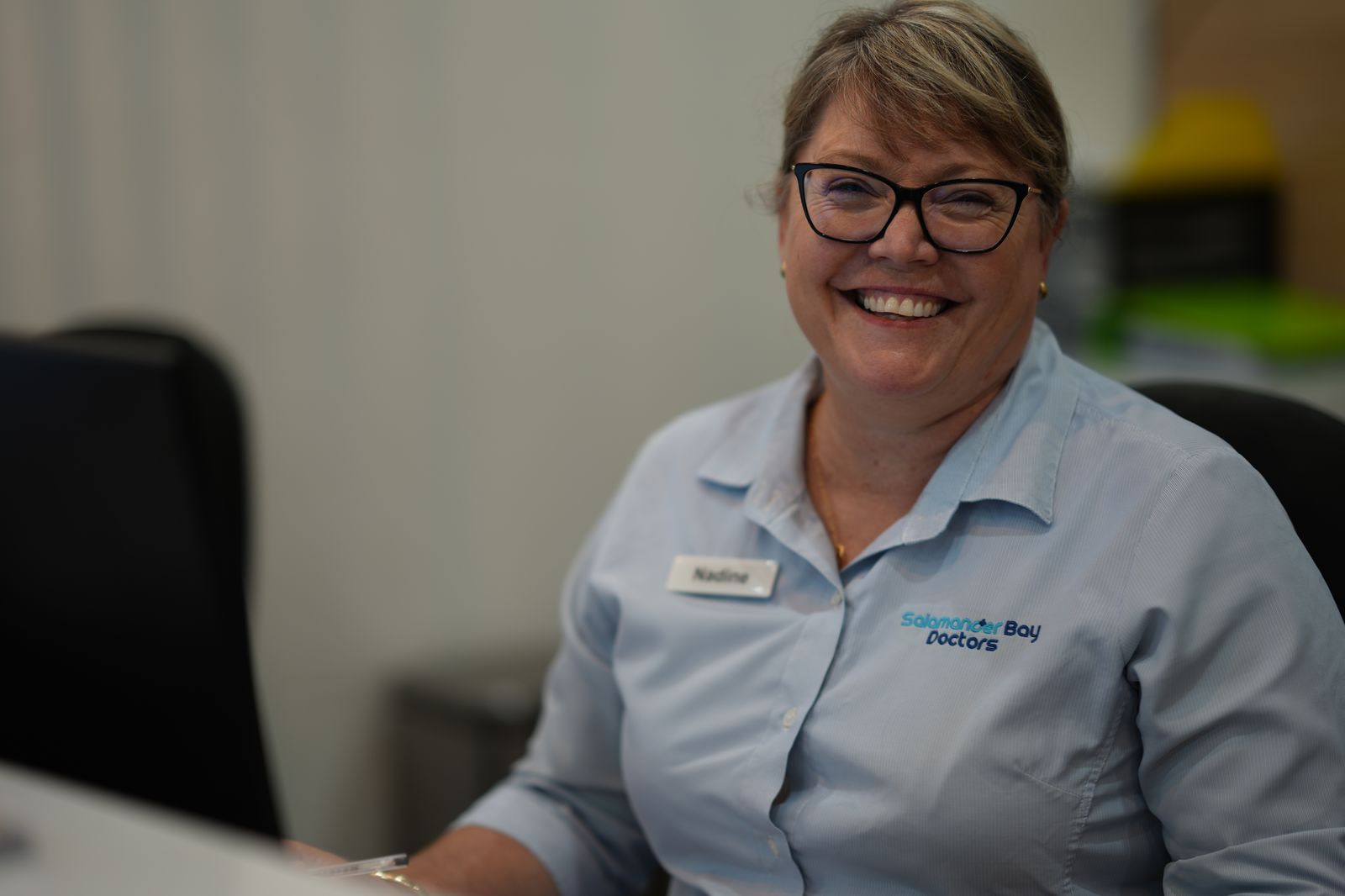 A member of the reception team smiling at the front desk