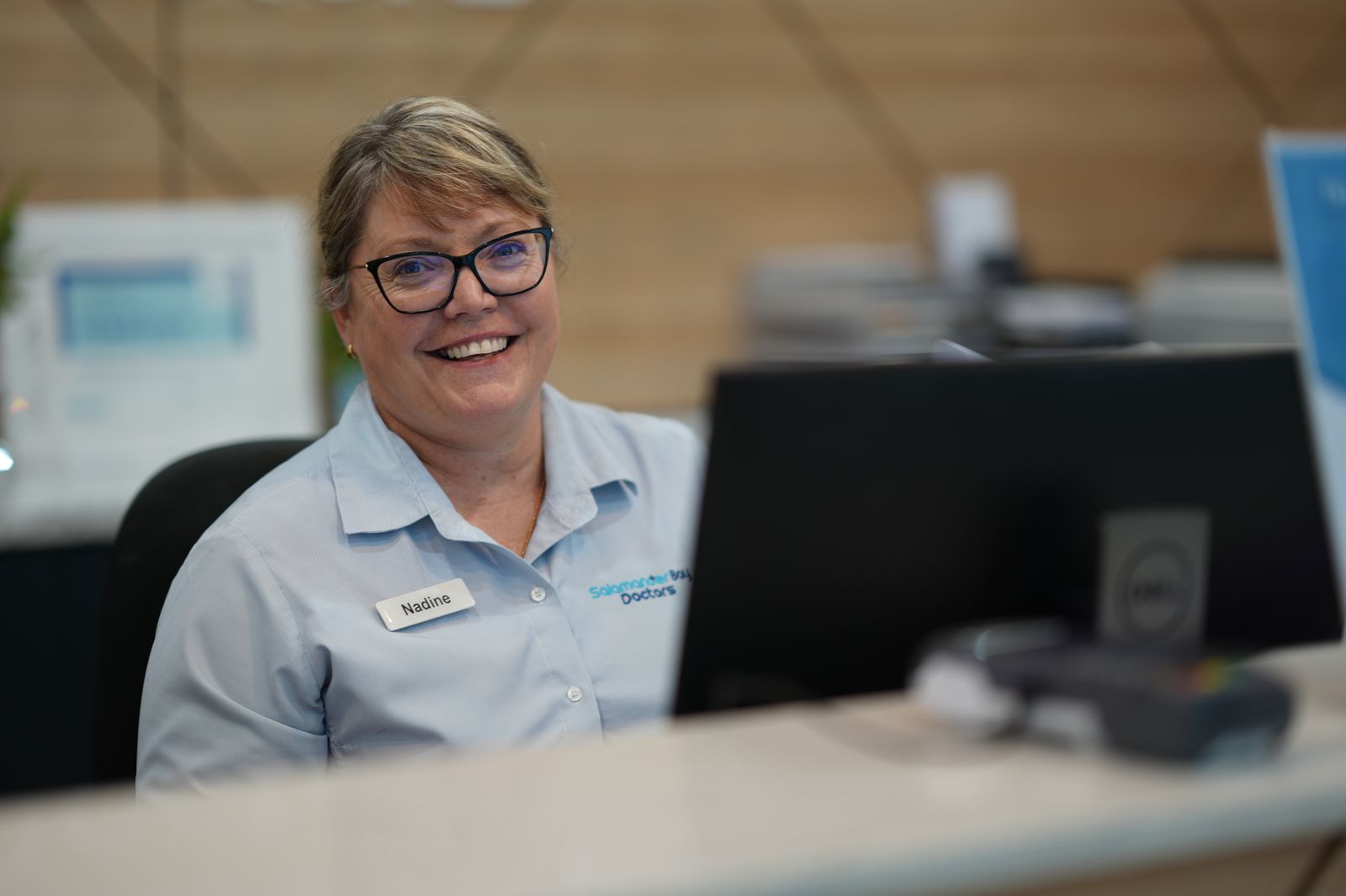 Reception staff welcoming a patient at the front desk