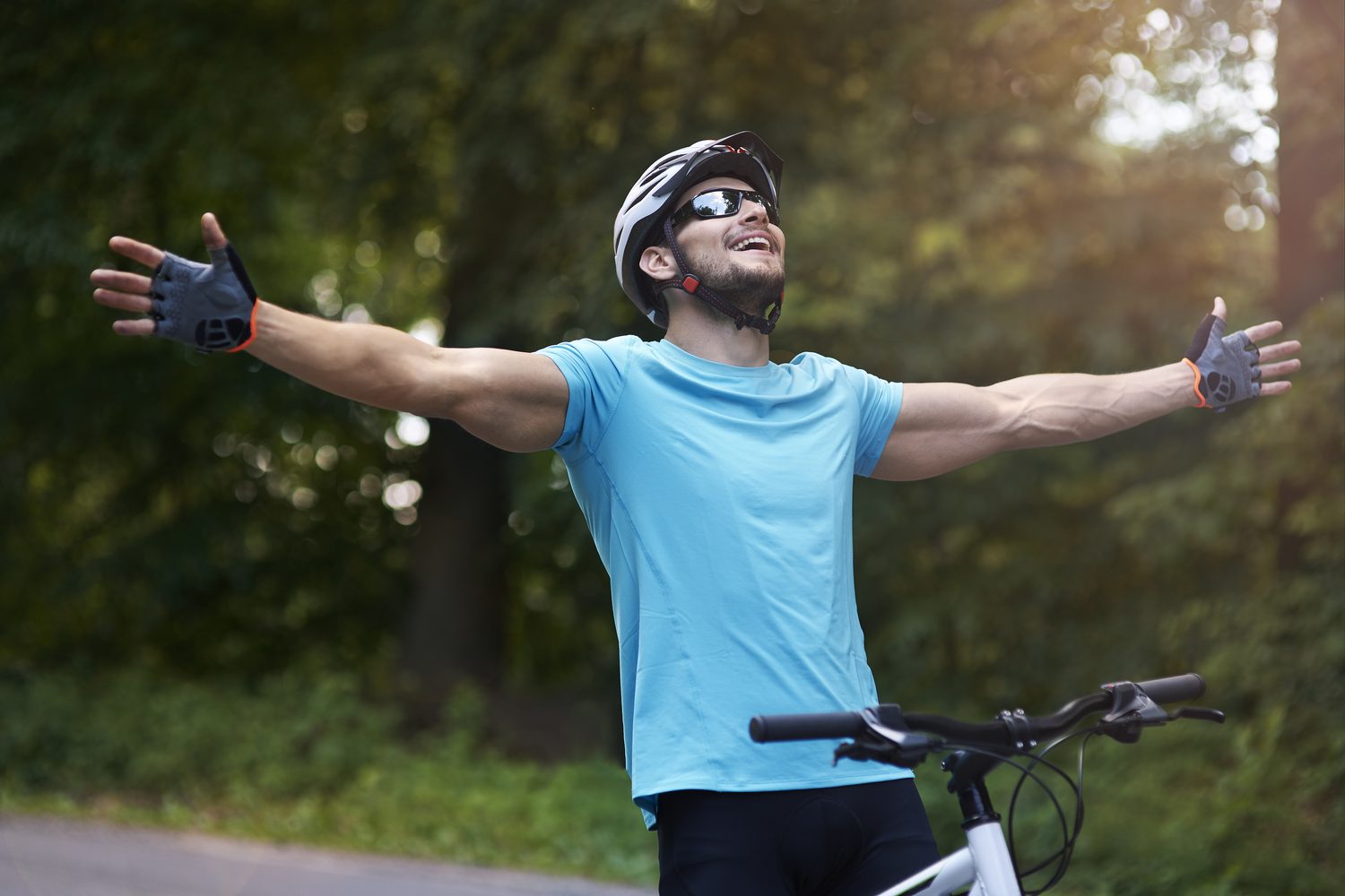 A cyclist stretching his arms out on a morning ride